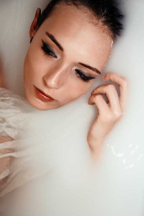 Close-up Of A Woman's Face With The Back Of Her Head Under Milky Water
