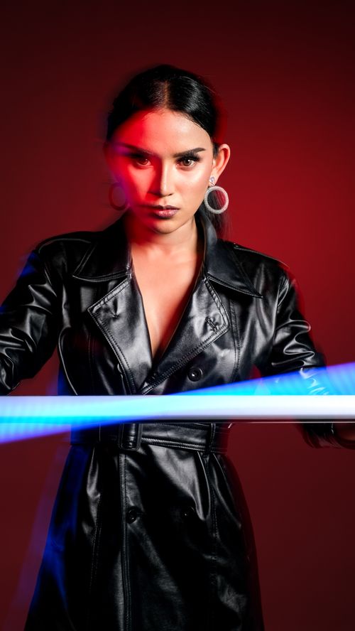 Free Dynamic portrait of a woman in leather with vibrant neon light effects. Stock Photo
