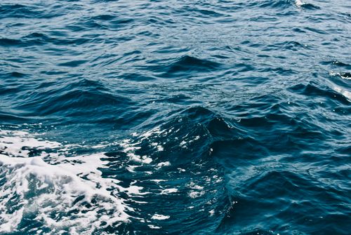 Free A mesmerizing view of ocean waves with dynamic seafoam and ripples, highlighting the motion of the sea. Stock Photo