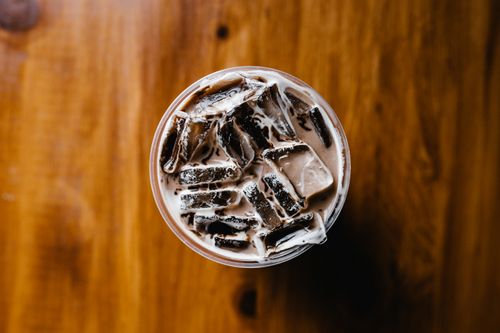 Free Top view of a refreshing iced coffee with milk on a wooden surface. Perfect for illustrating beverage concepts. Stock Photo