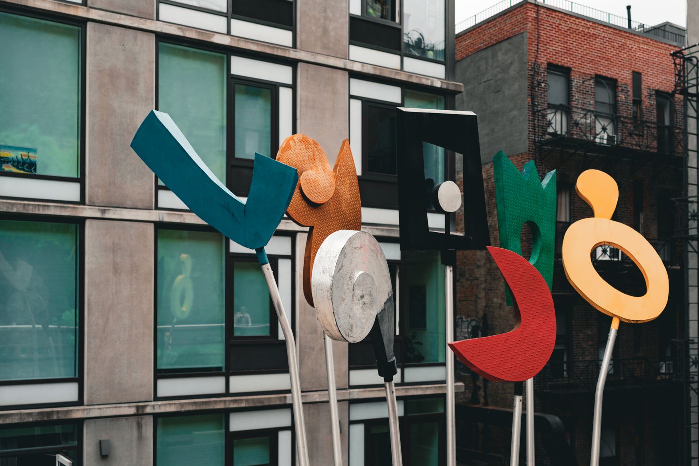 Painted abstract sculptures in front of a city building — photo by Mario Spencer on Pexels