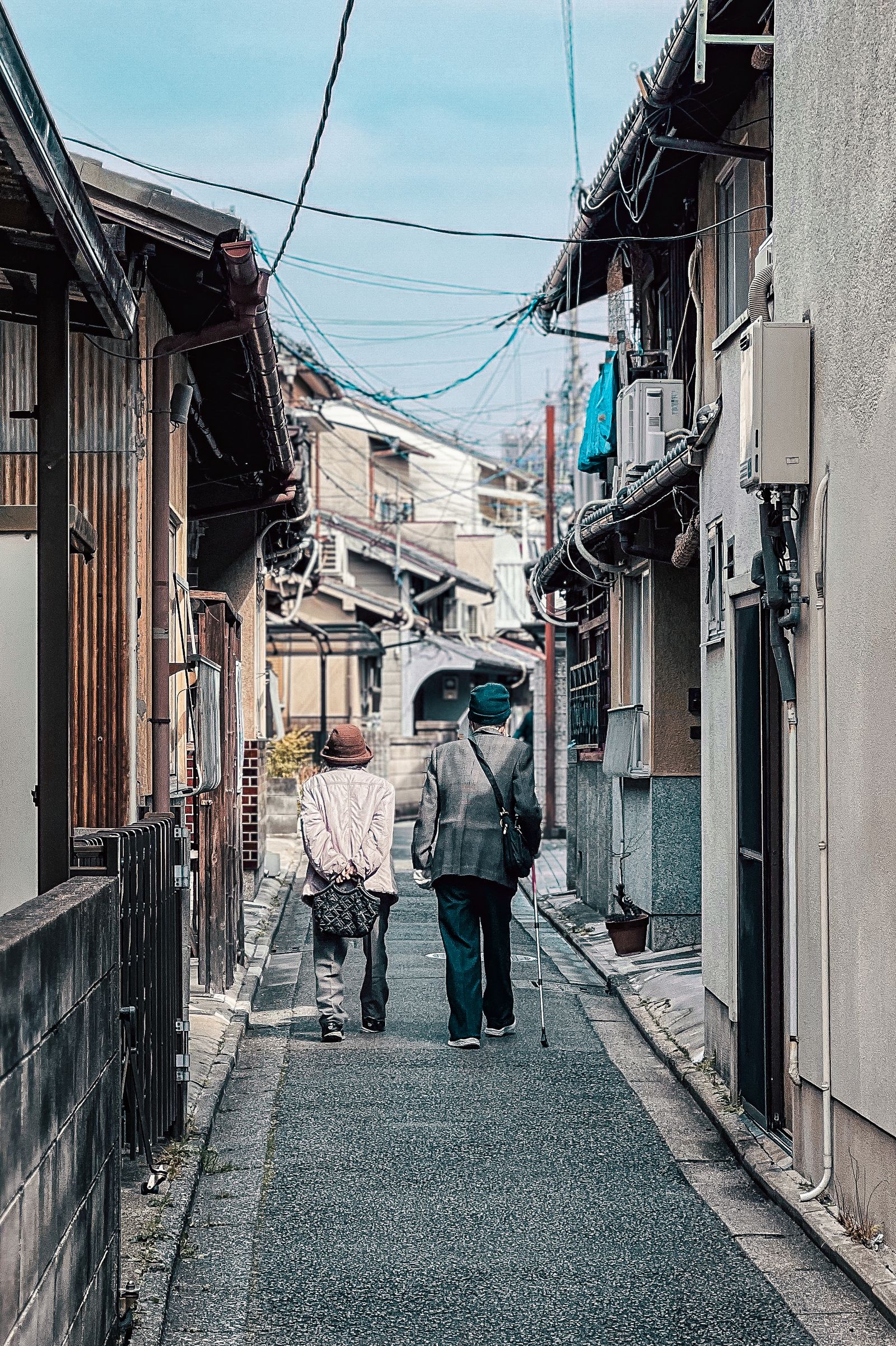 京都の伝統的な路地を寄り添って歩むご夫婦