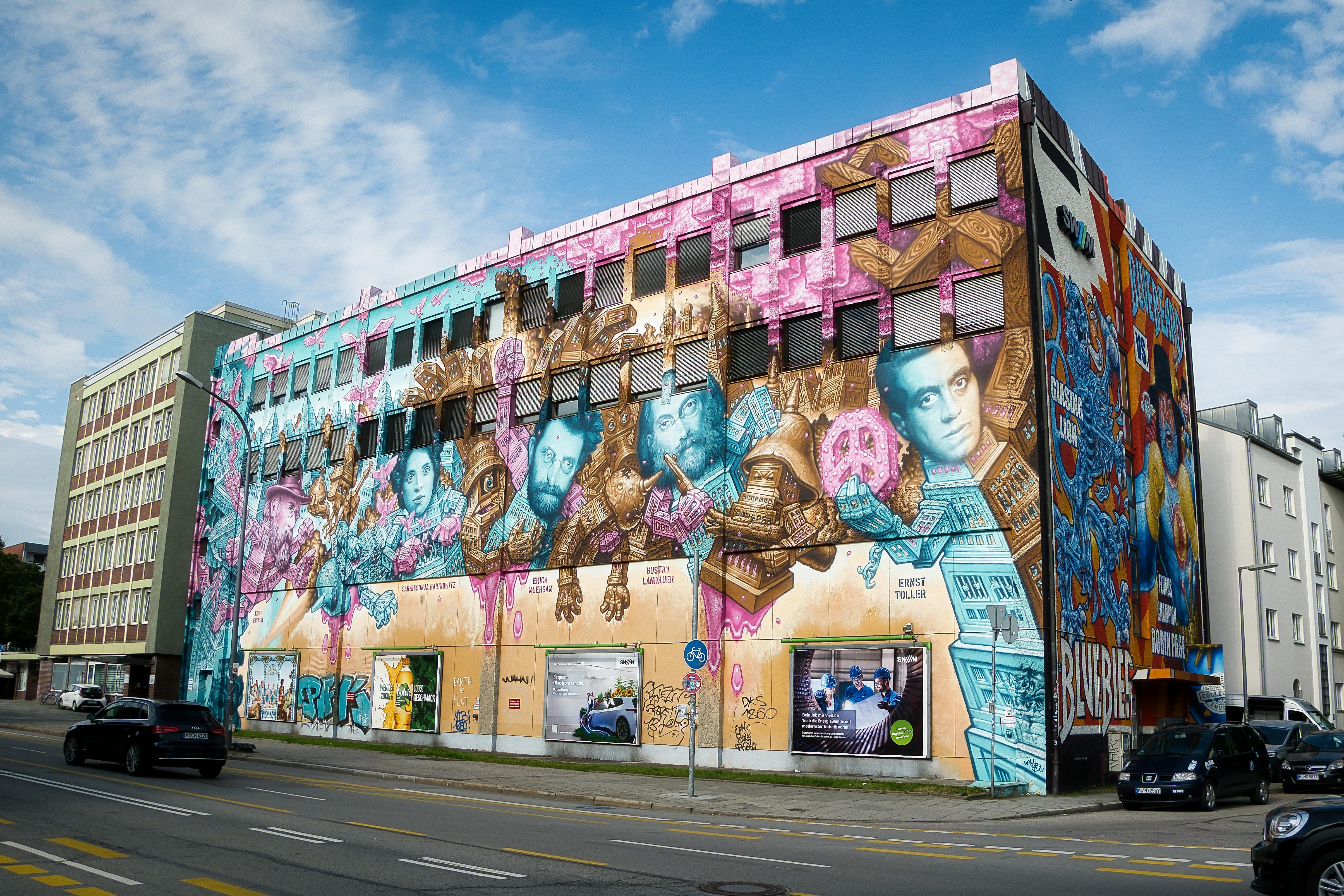 ingyenes Münchenben egy egész épület homlokzatát színes utcai művészet borítja, bemutatva a különböző művészeti stílusokat. Stockfotó