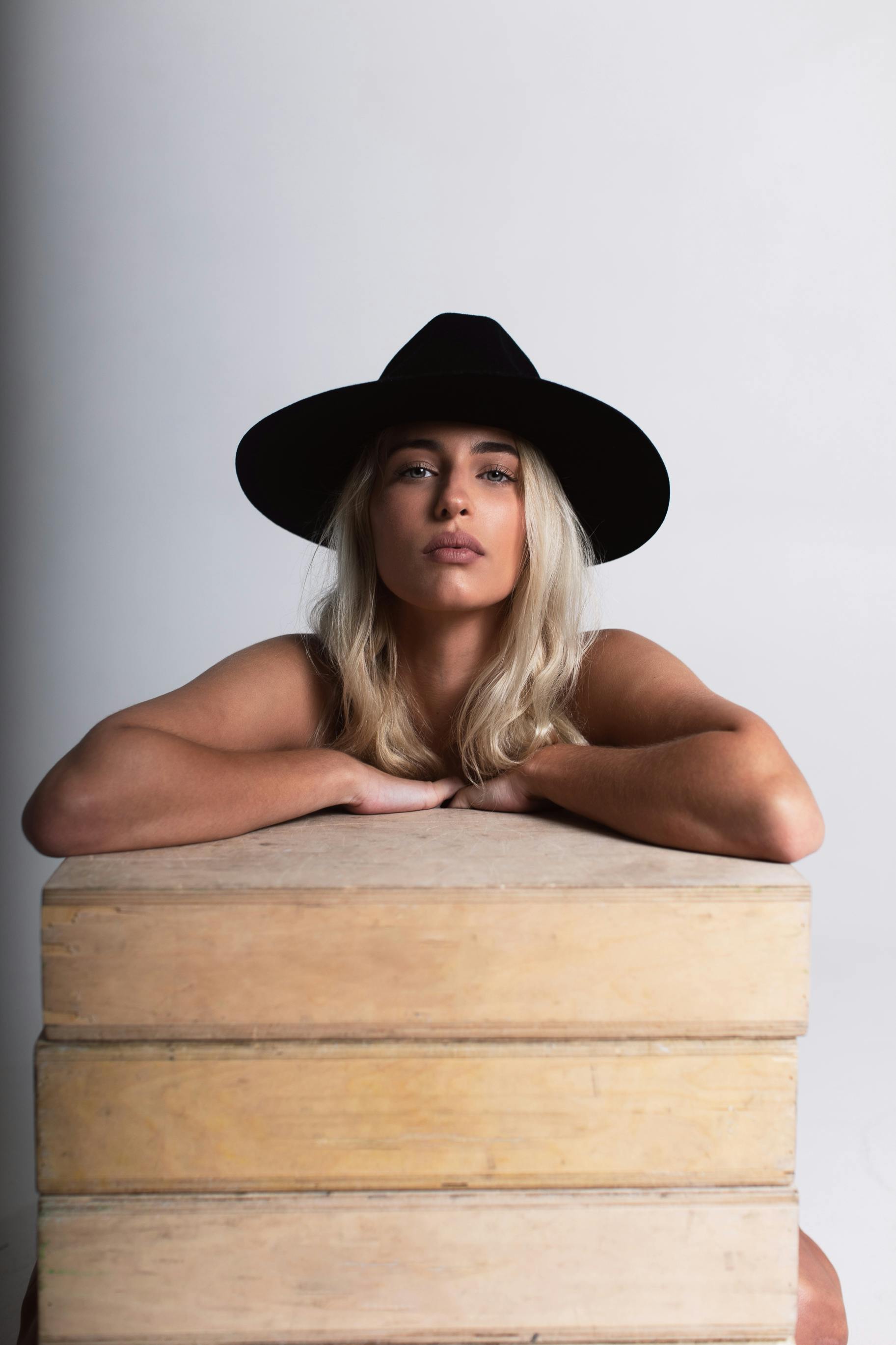 photo of woman leaning on wooden surface