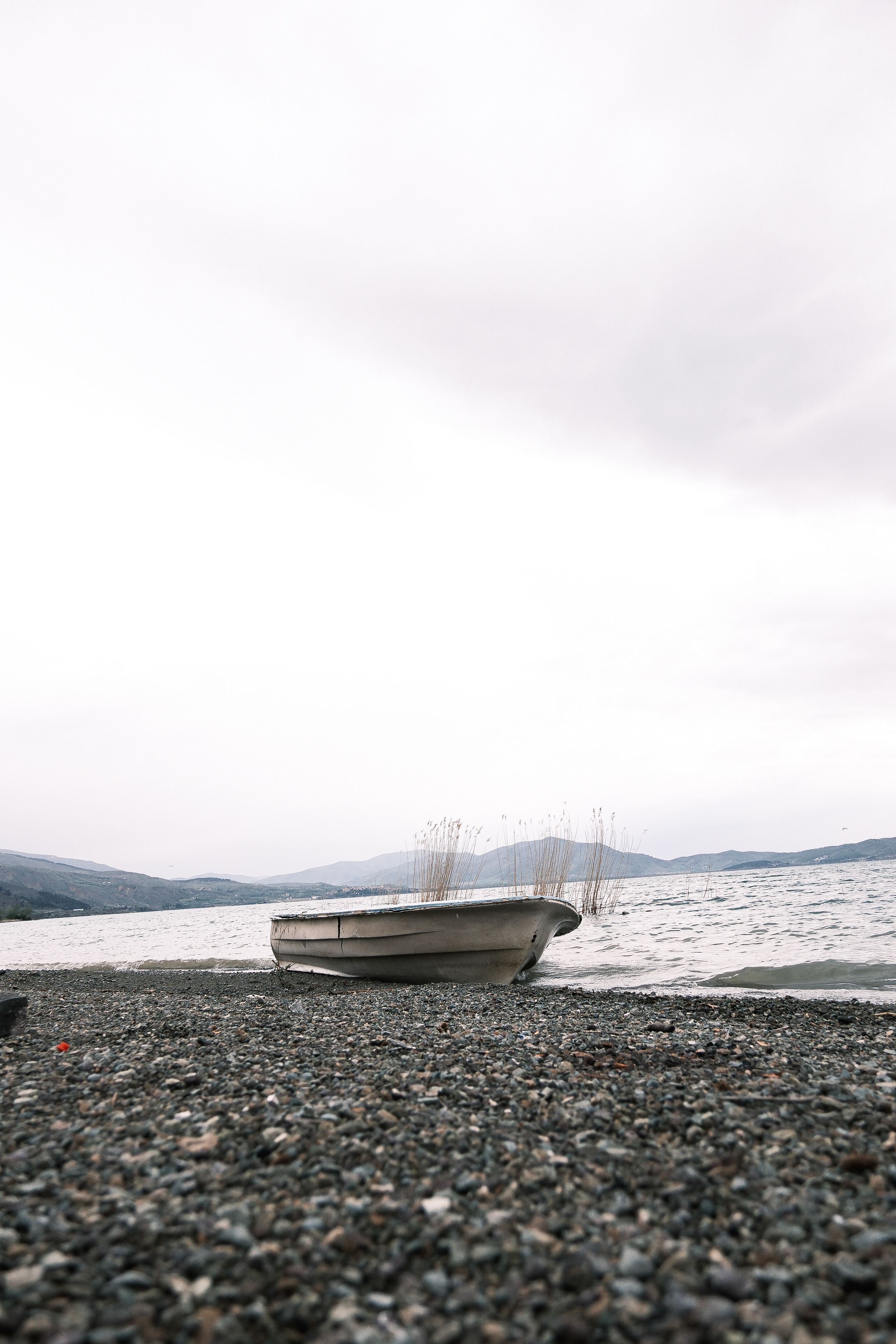 Abandoned Boat on a Tranquil Pebble Beach · Free Stock Photo