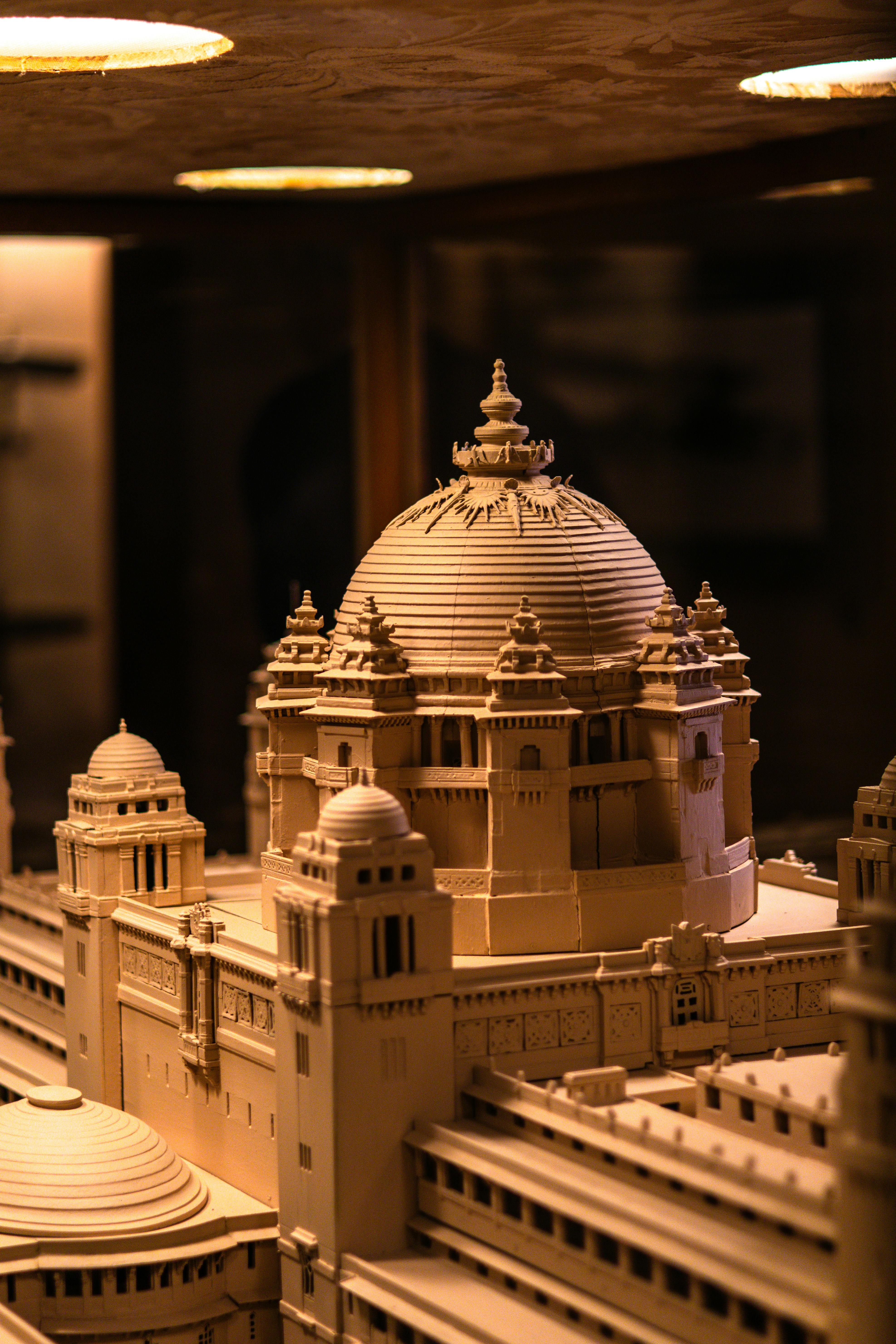 grátis Maquete arquitetônica complexa exibindo design clássico com cúpulas e torres, capturada em iluminação quente. Foto profissional