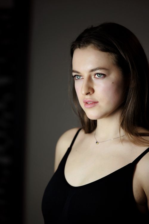 Free A contemplative portrait of a woman gazing into the distance in soft lighting. Stock Photo