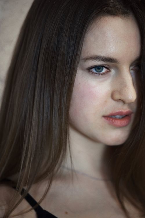 Free Close-up portrait of a young woman with long brown hair looking to the side. Stock Photo