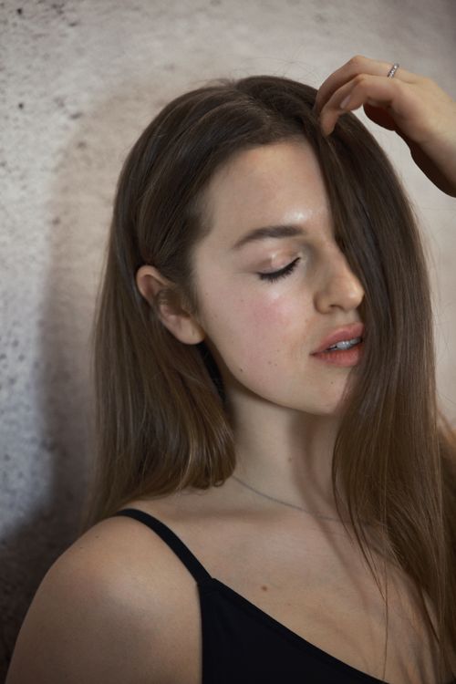 Free Close-up of a young woman with long hair, serene expression Stock Photo