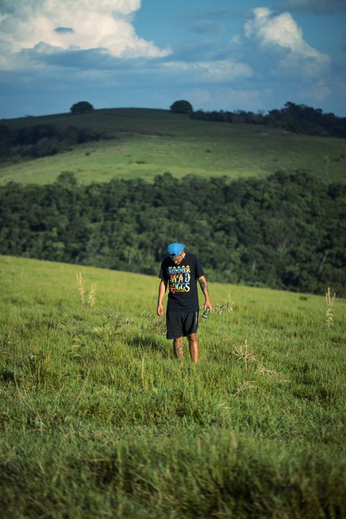 Man in Field with Scenic View of Grassland and Hills · Free Stock Photo