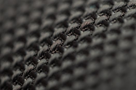 Detailed view of black woven fabric showcasing intricate texture and weave pattern.