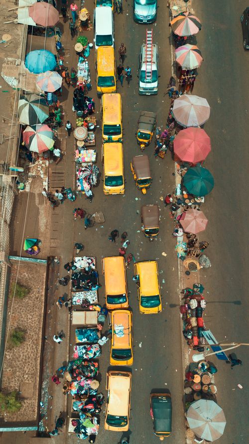 Crowded outdoor market with vendors selling goods from temporary stalls in an informal urban settlement