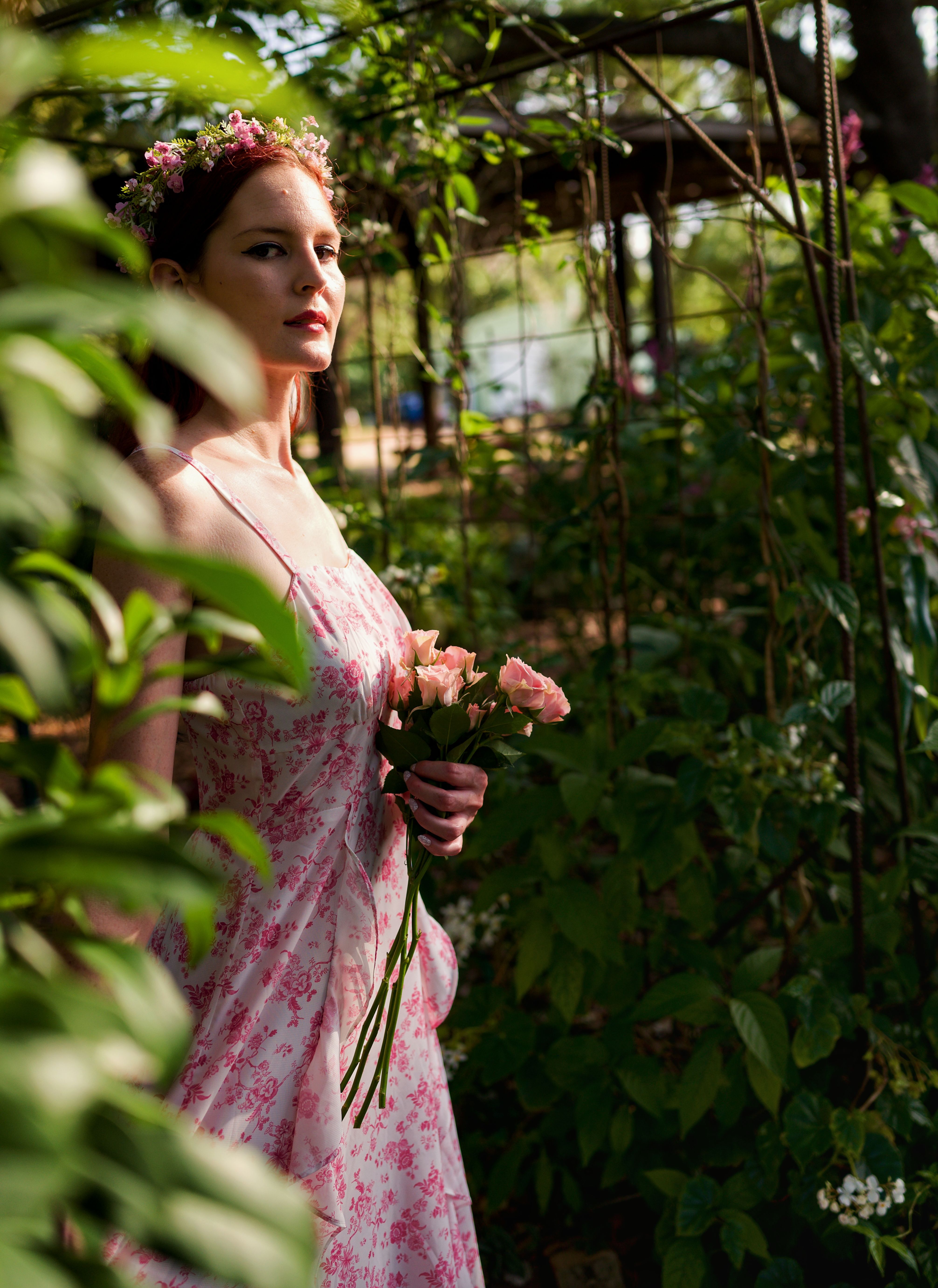 Elegant Woman in Floral Dress Holding Roses Outdoors · Free Stock Photo