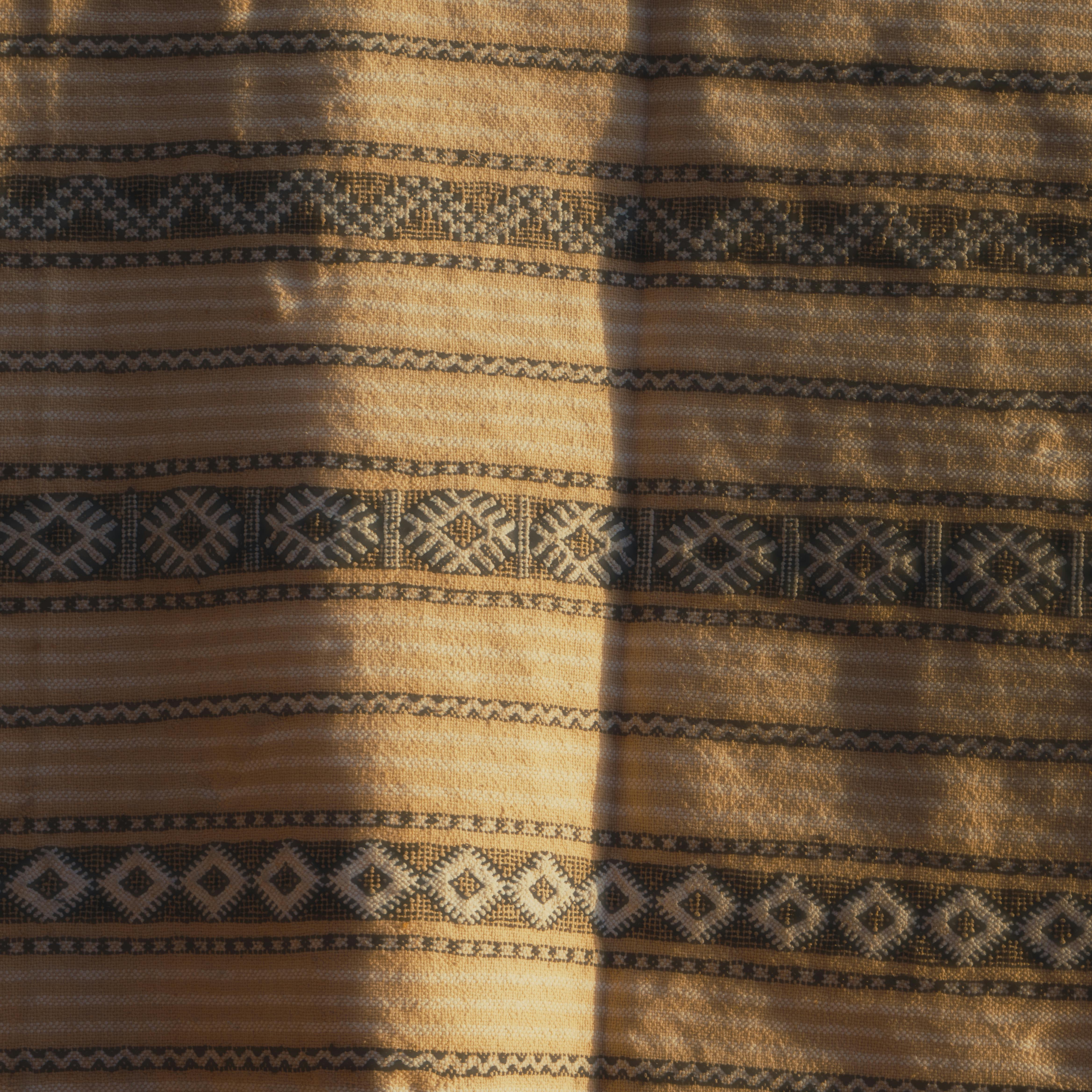Close-up of a Moroccan textile design featuring traditional geometric patterns in warm tones.