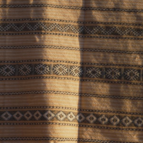 Geometric woven textile in warm tones — photo by Hicham Chakir on Pexels