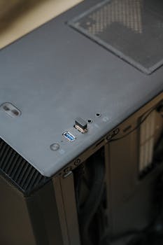 Detailed view of a computer tower's USB ports and ventilated top panel, emphasizing technology maintenance.