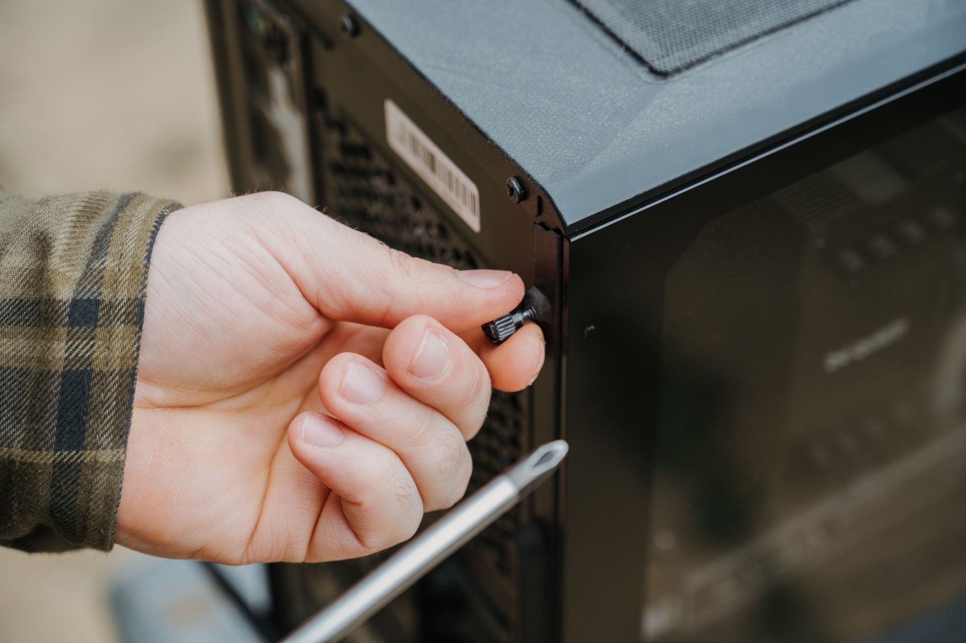 A professional IT technician performing maintenance on a server rack in a business environment