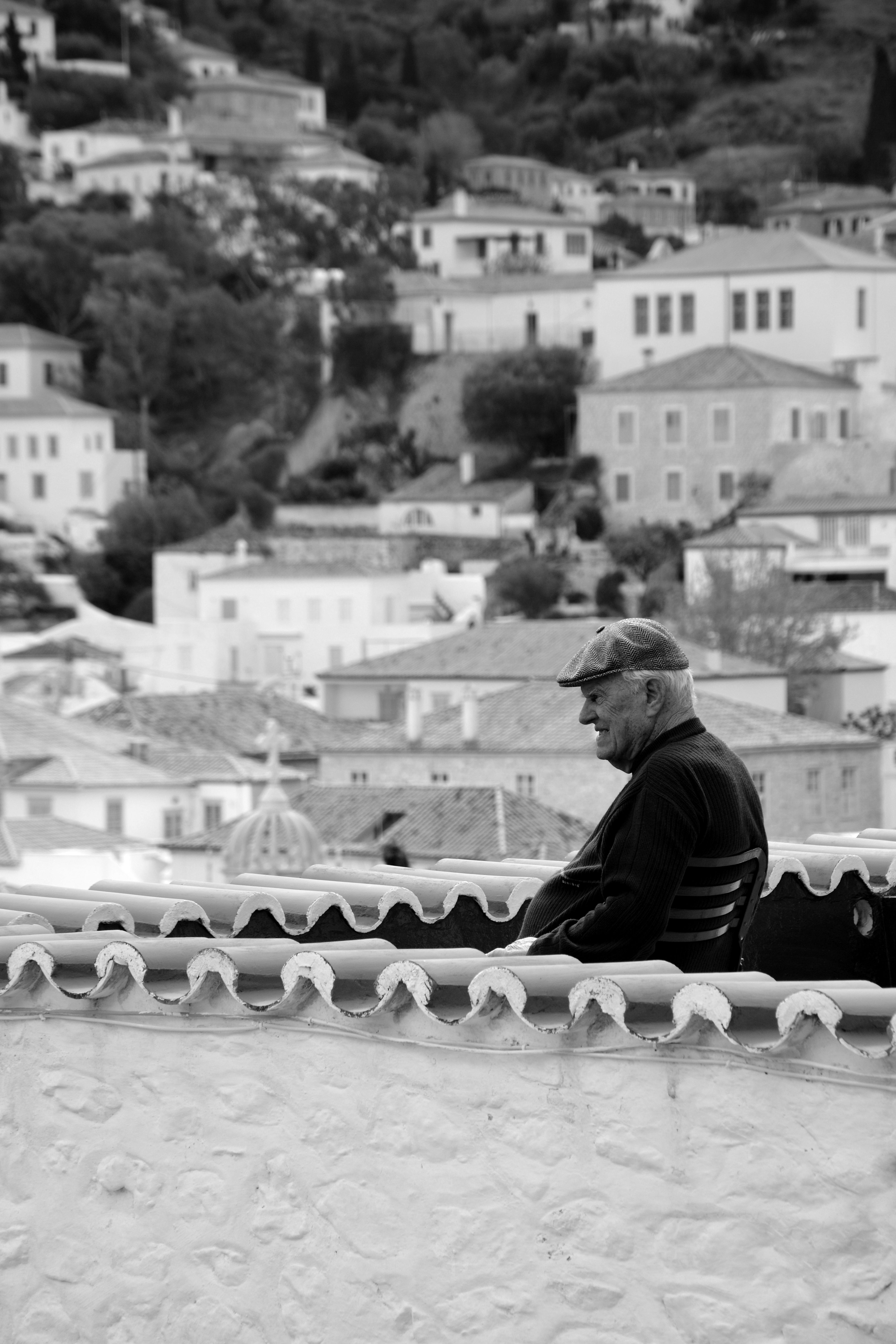 Serene View of a Senior Man Overlooking Hillside Town · Free Stock Photo