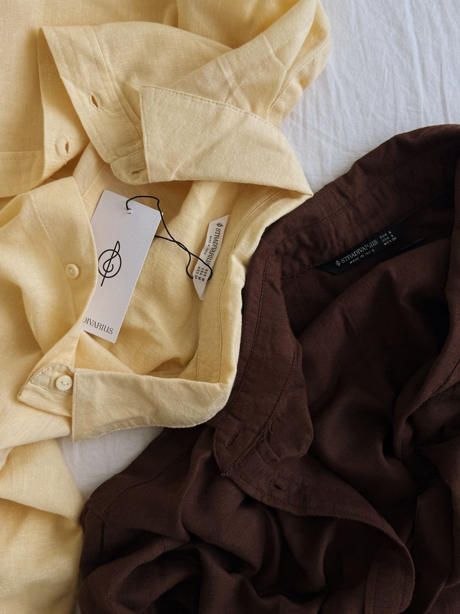 Folded linen shirts in warm neutral colors without people