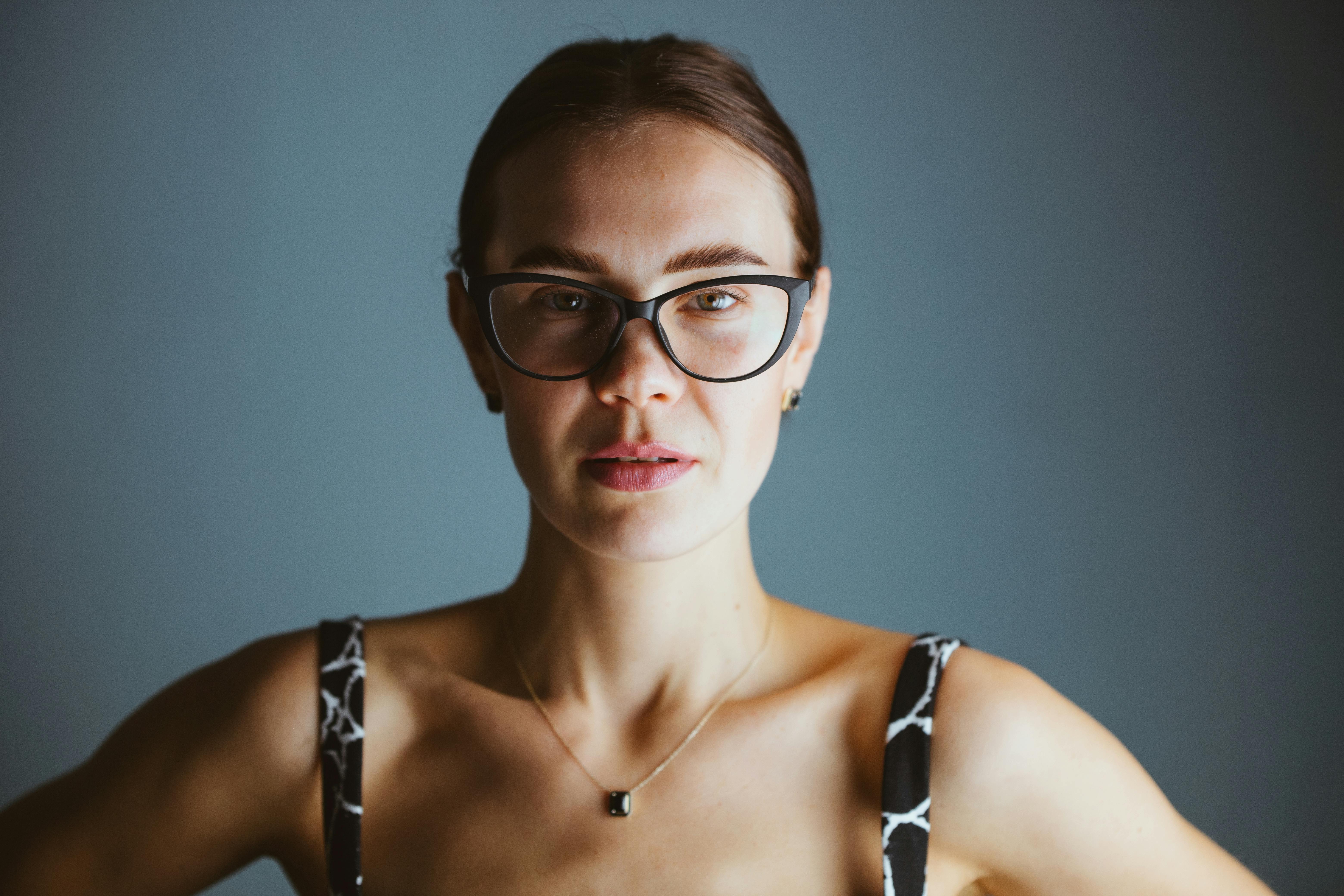 Kostenlos Eine junge Frau mit Brille posiert selbstbewusst und strahlt eine moderne und stilvolle Ausstrahlung aus. Stock-Foto