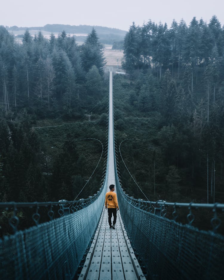 Man Walking On Suspension Bridge