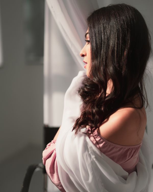 Elegant Woman Posing Indoors with Natural Light · Free Stock Photo