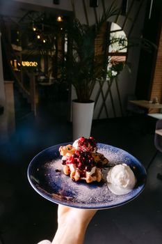 Indulge in delicious gourmet waffles topped with fresh berries and a scoop of ice cream.
