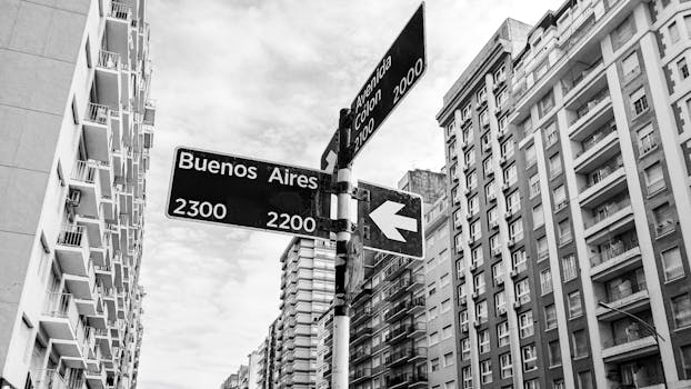 Street sign in Buenos Aires with surrounding architecture in black and white.