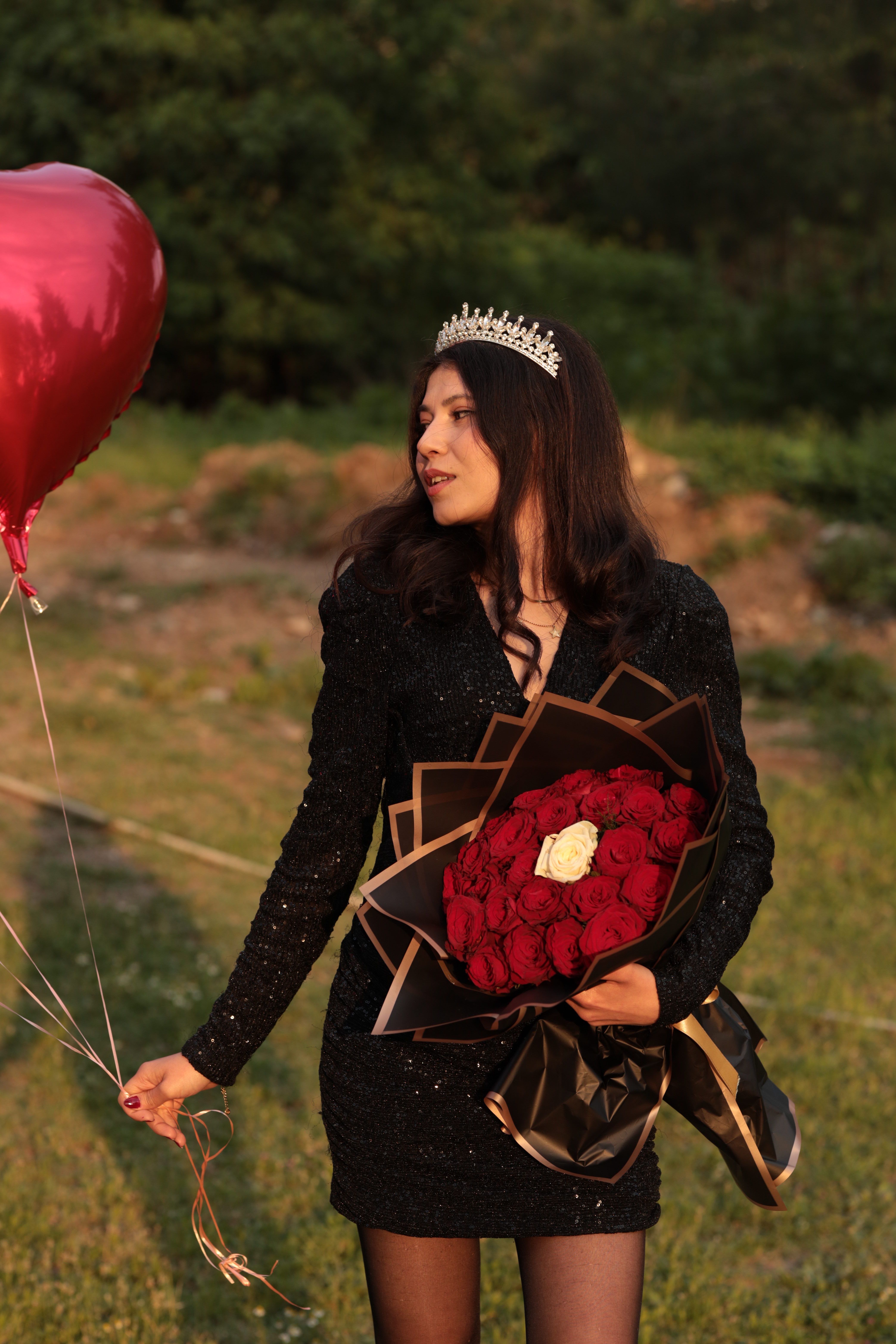 Woman in Black Dress Holding Red Roses Outdoors · Free Stock Photo