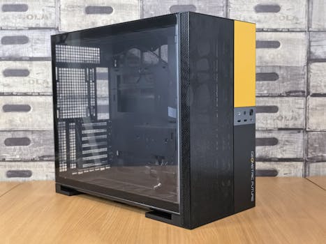 Modern computer case with glass panel, black and yellow design, on a wooden desk indoors.