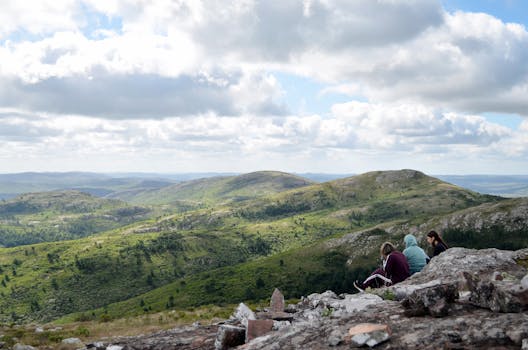 Hikers enjoying the view of lush green hills and cloudy skies in Sierra de las Ánimas, Maldonado.