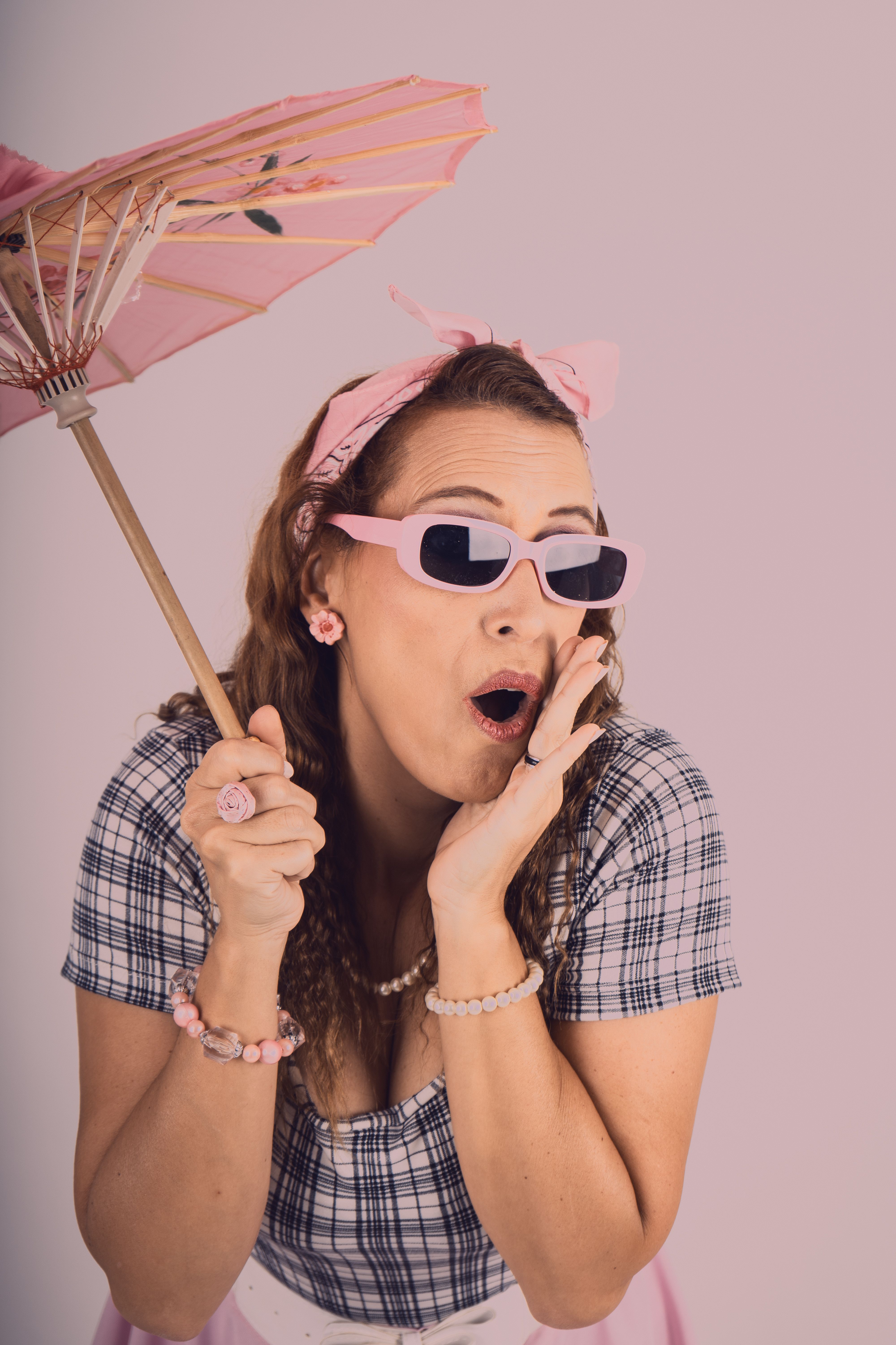 A surprised woman in vintage attire holding a parasol in a retro style setting.