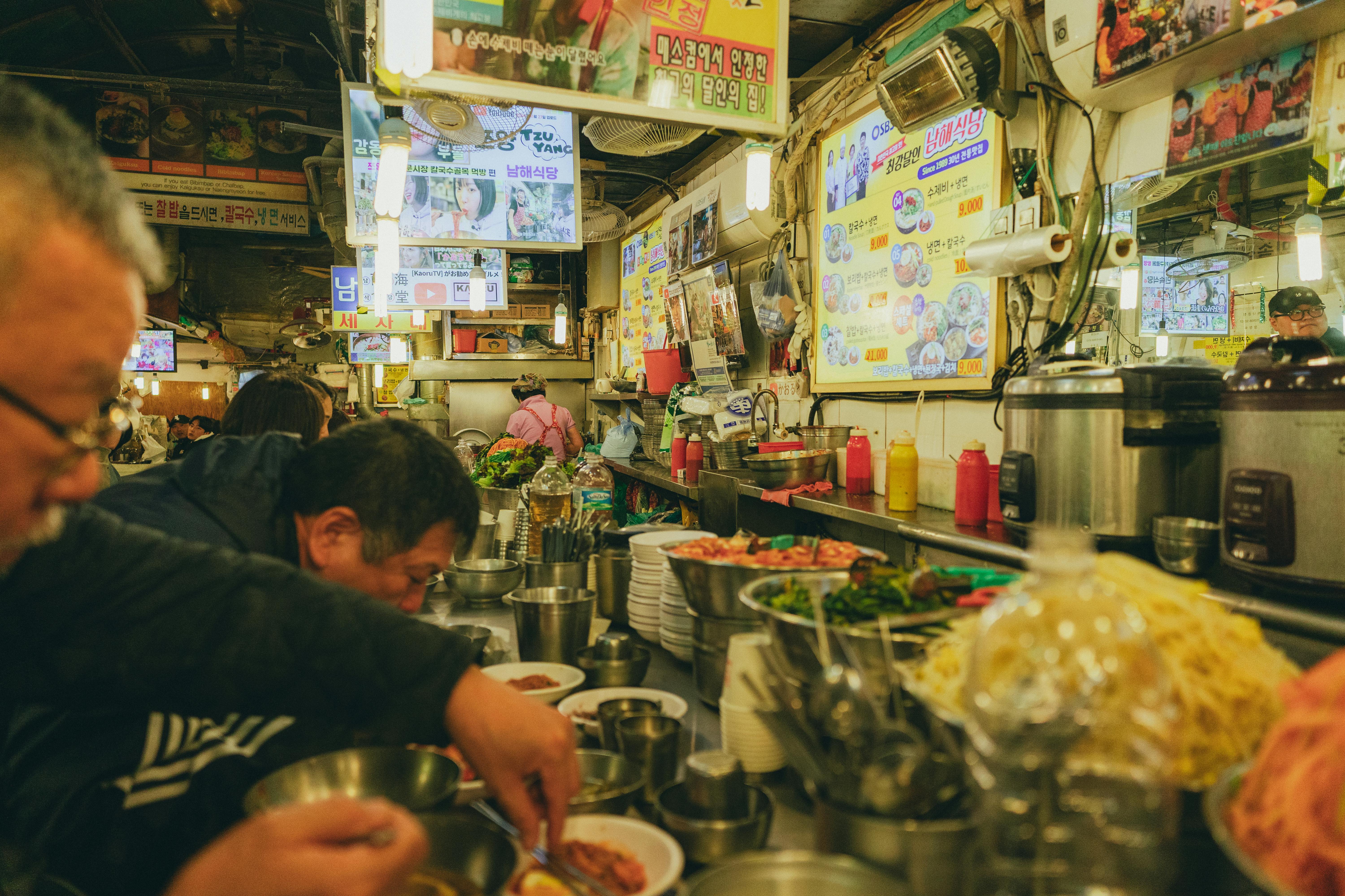 Vibrant street food market scene in Seoul, showcasing a local Korean restaurant with bustling activity.