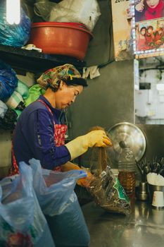 A street vendor prepares noodles in a vibrant Seoul market, showcasing Korean culture and cuisine.