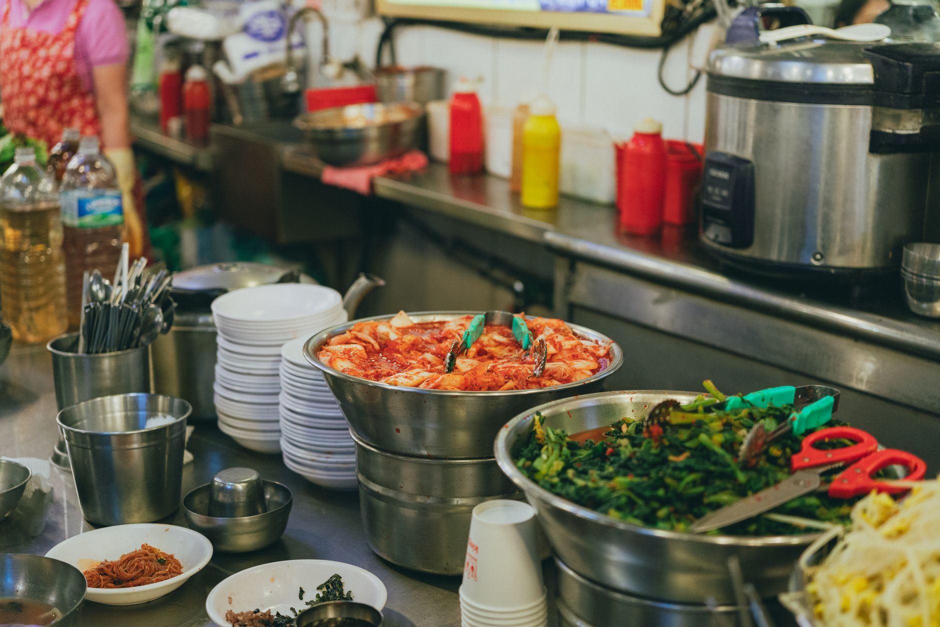 Colorful display of traditional Korean dishes in a bustling Seoul market setting.
