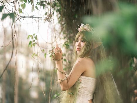 Captivating fairy with floral crown in mystical forest setting, evoking fantasy and magic.