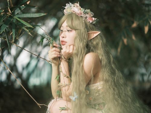 Free A whimsical portrait of a forest elf with floral crown and elf ears, surrounded by lush greenery. Stock Photo