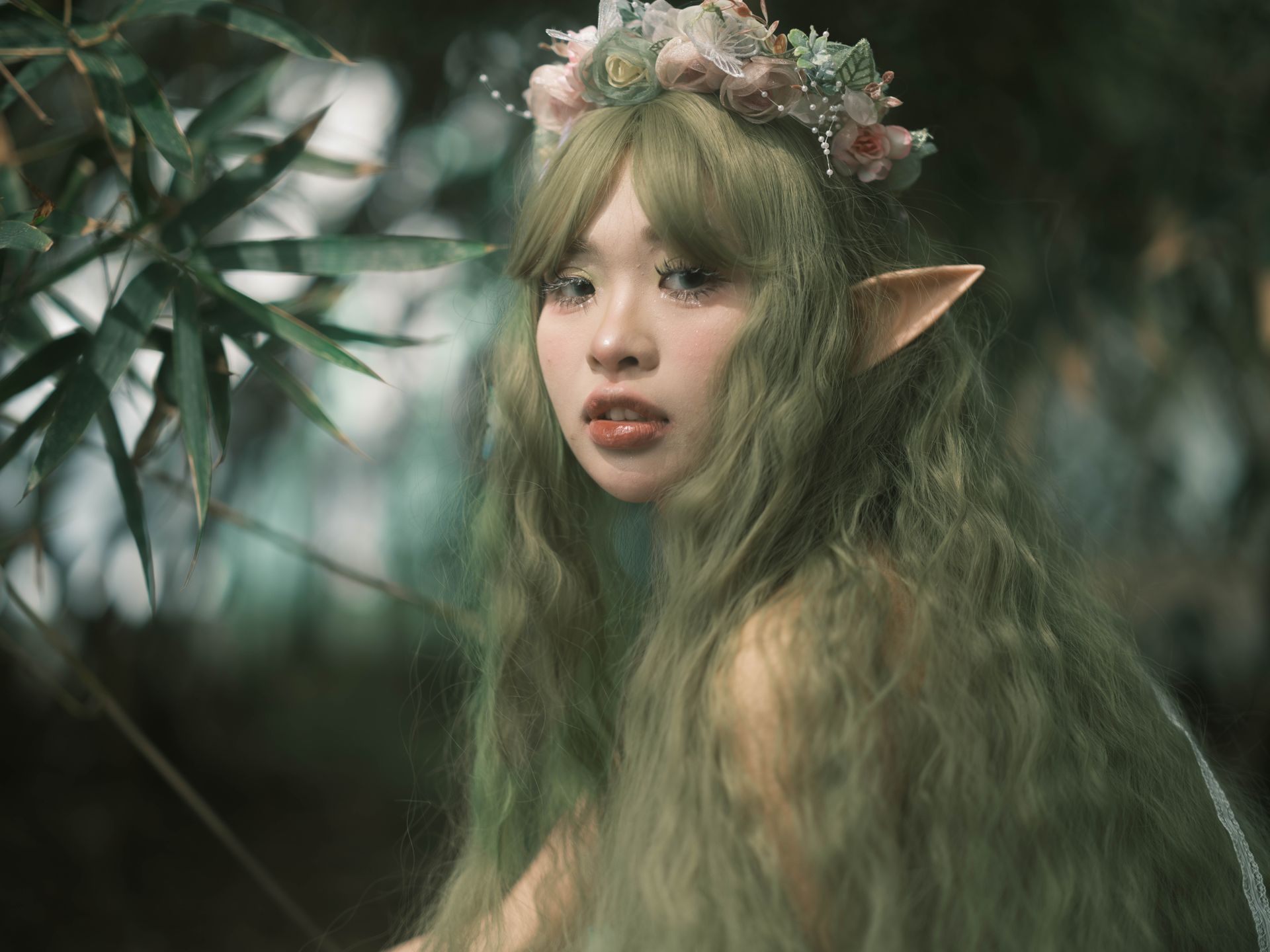 A magical portrait of an elf woman with floral crown and pointed ears in a lush forest.