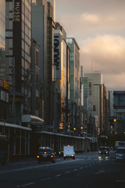 Free Evening city street scene with modern architecture and traffic in the golden hour light. Stock Photo