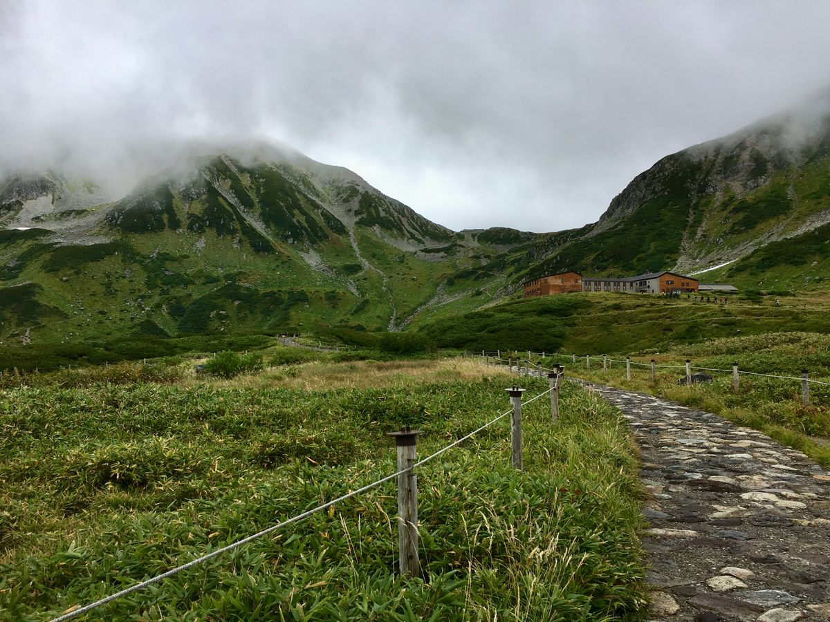Beginner hiker walking a well-marked trail through Japanese mountains