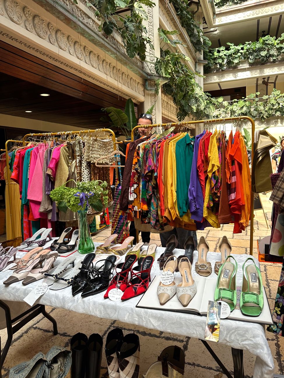 Pre-loved jackets and shoes arranged on dense rails like a temporary boutique floor