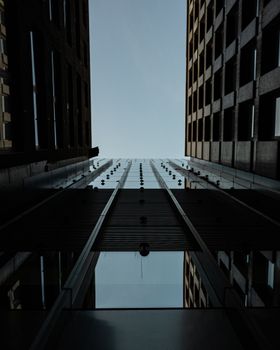 Looking up at modern skyscrapers in Sydney, showcasing sleek architectural reflections against a clear sky.