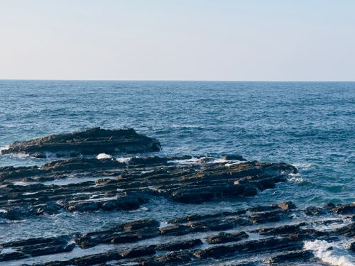 Free Beautiful coastal rock formations with blue ocean waves during the day. Stock Photo