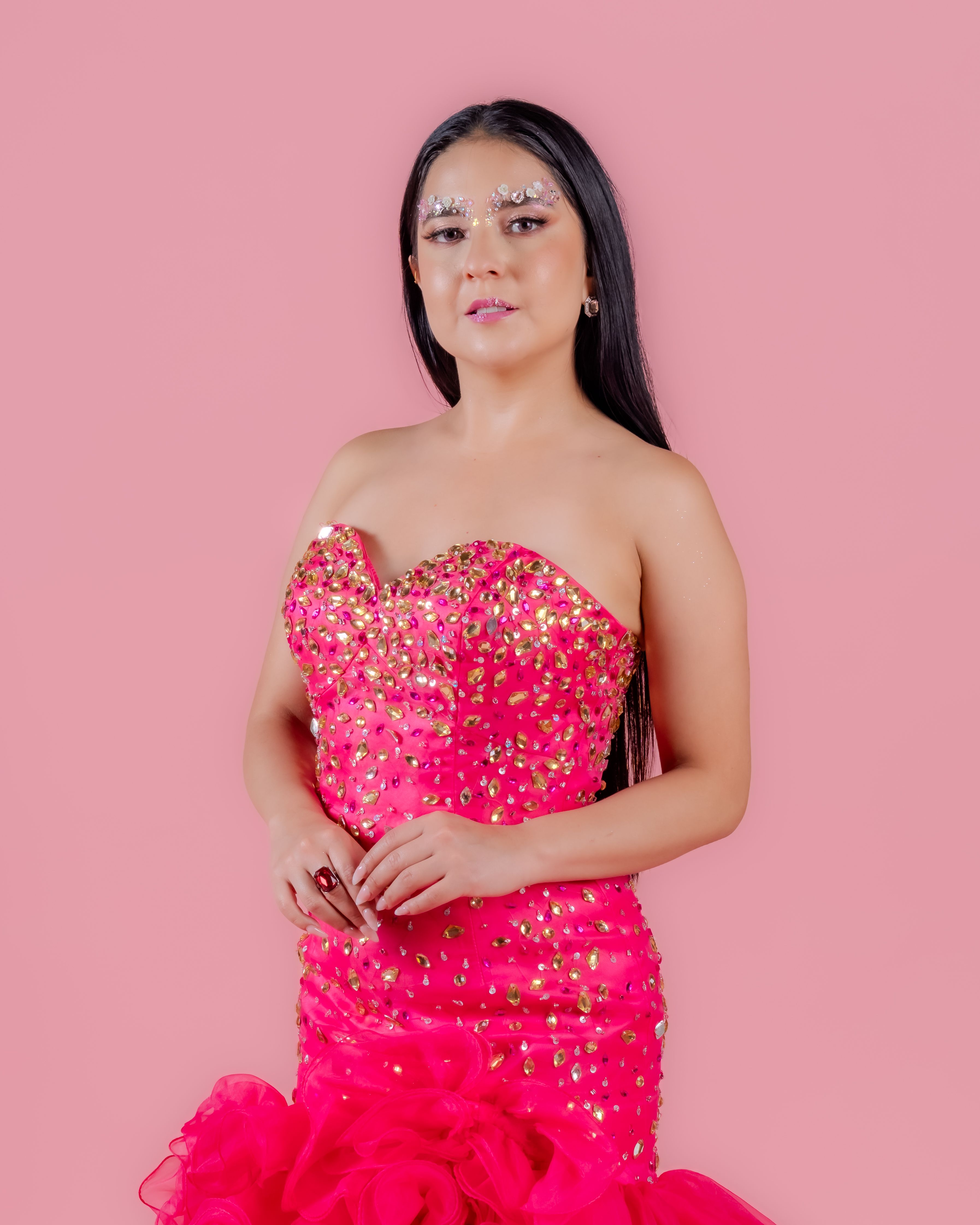 Portrait of a stylish woman in a sparkling pink dress with creative makeup, exuding elegance and empowerment.