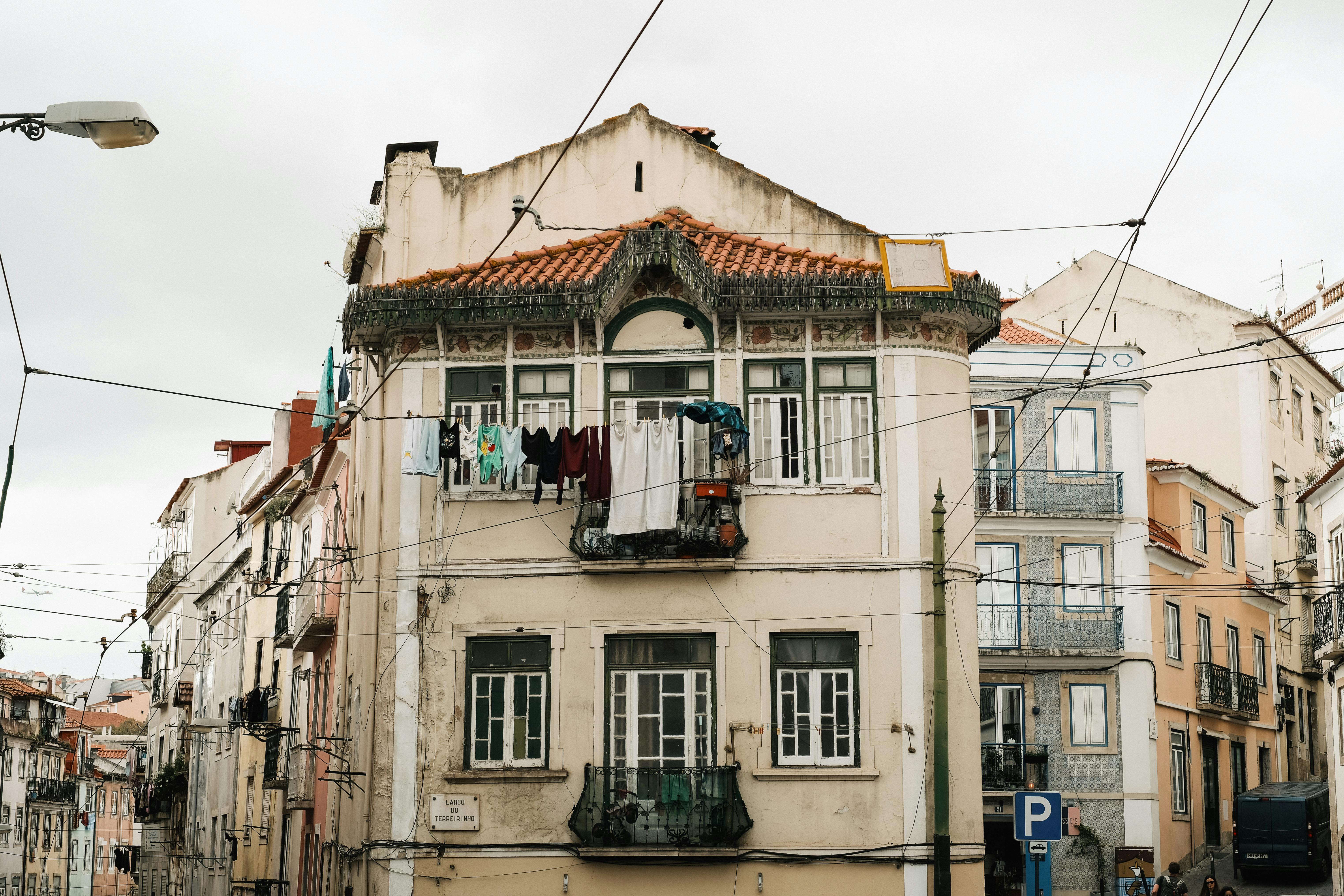 A quiet residential street in a European city, with laundry hanging and a cat sitting on a doorstep