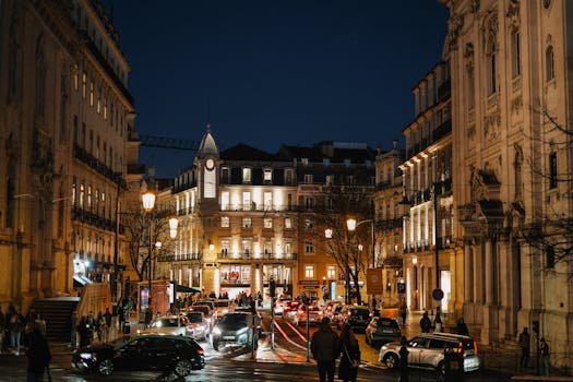 Bustling urban scene at night in Lisbon with classic architecture and lively streetlights.