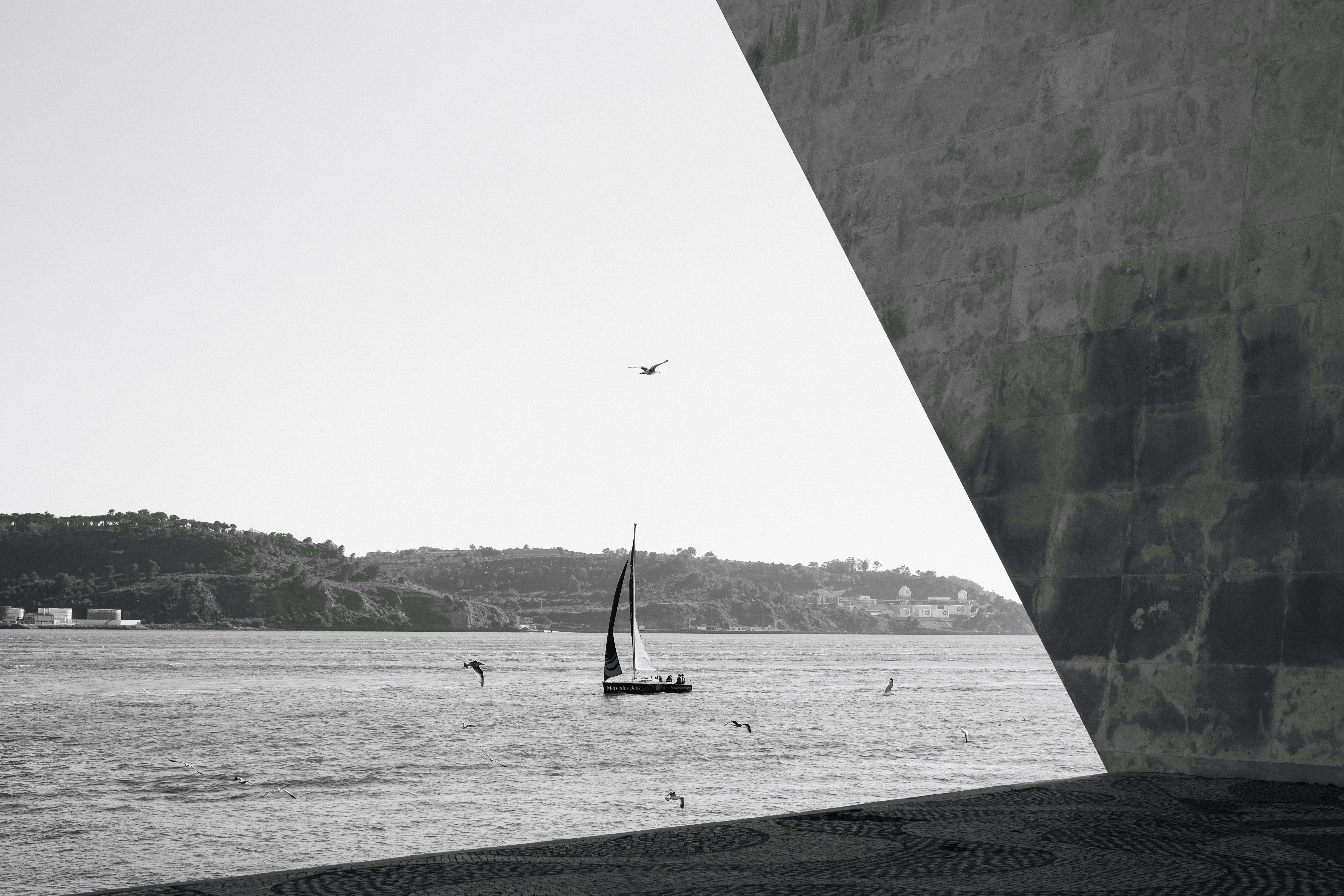 Black and white sailboat scene framed by a massive granite structure.