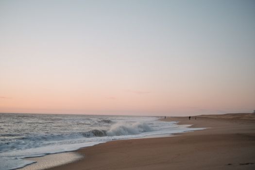 A peaceful beach view at sunset with gentle waves and a pastel sky, perfect for relaxation vibes.