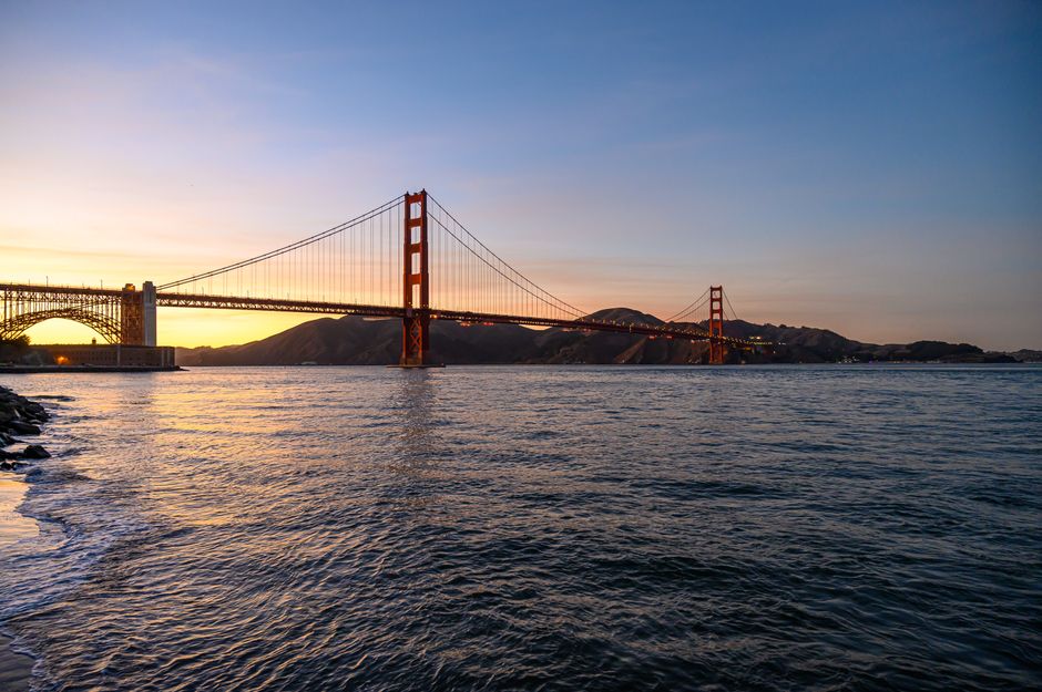 Scenic view of the Golden Gate Bridge at sunset with a calm ocean in San Francisco.