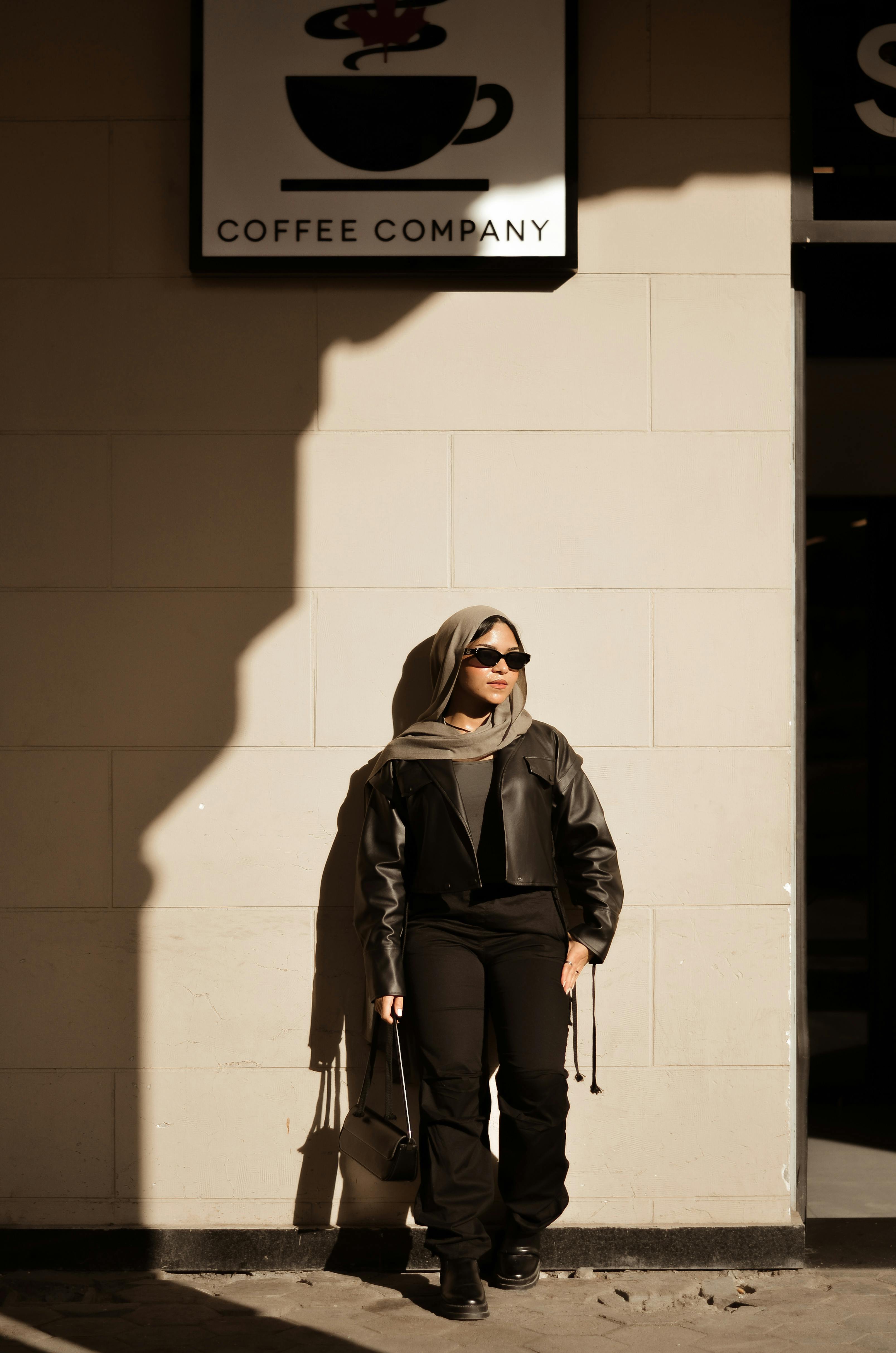 Gratis En moderigtig kvinde i hijab står selvsikkert uden for en café i Kairo, Egypten. Lagerfoto